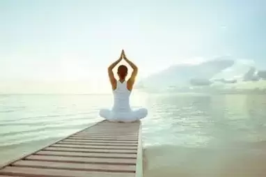 mulher em meditação junto ao lago